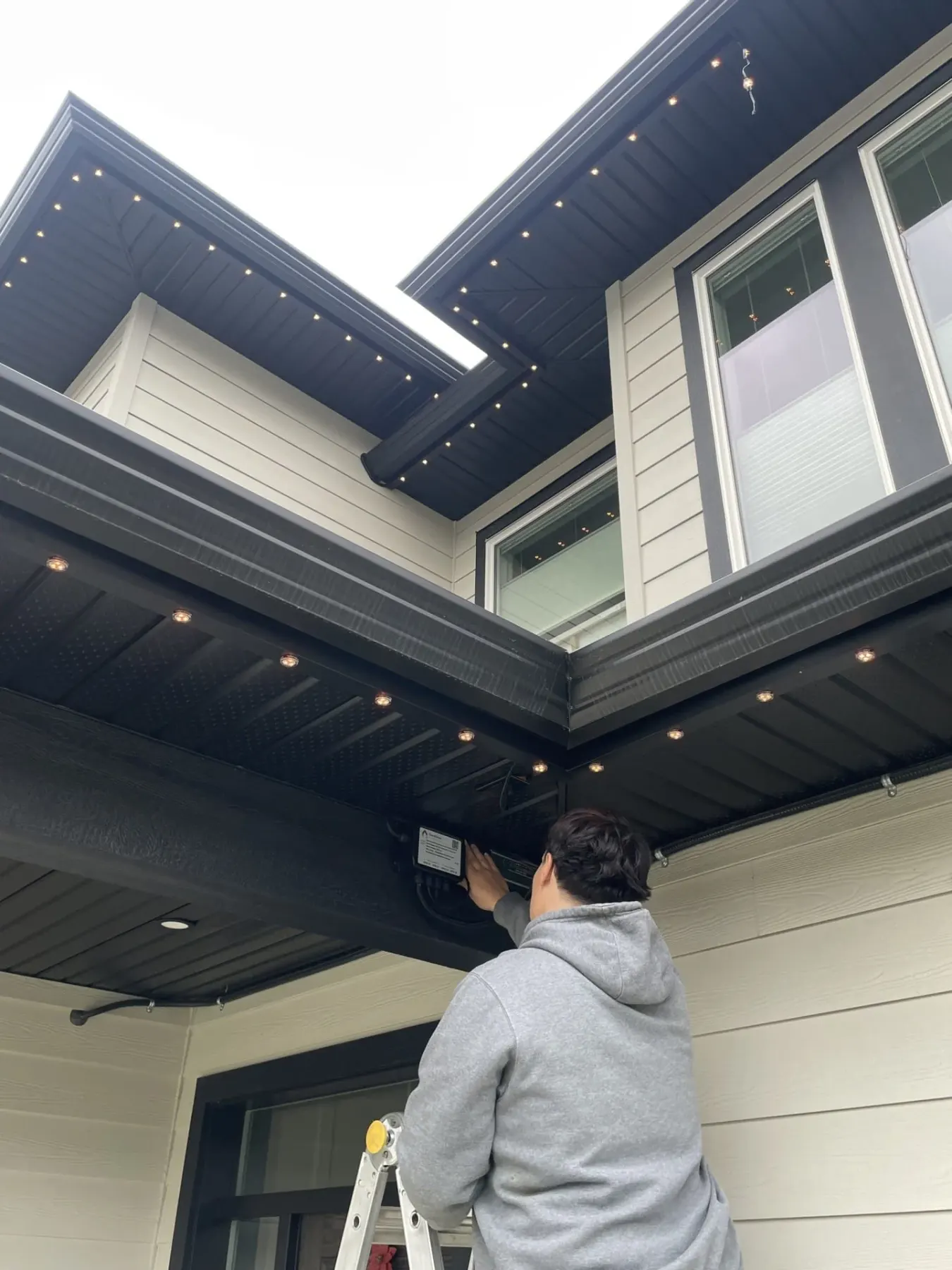Installer fitting pucks into aluminum track under a soffit